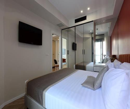 a bedroom with a large bed with a television on the wall at West Tel Aviv- All Suites Hotel By The Sea in Tel Aviv