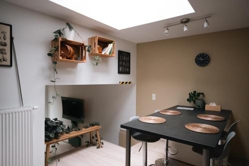 d'une salle à manger avec une table, des chaises et une télévision. dans l'établissement La petite Citadelle - l'appartement, à Namur