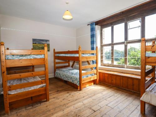 a bedroom with two bunk beds and a window at Nethercott House in Winkleigh