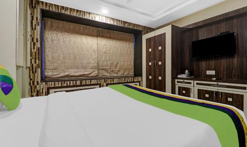a bedroom with a large bed and a tv at Treebo Elite Premium Homes in Bengaluru