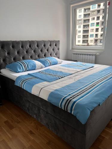 een groot bed met blauwe kussens in een slaapkamer bij 3RooM Deluxe Sarajevo in Sarajevo