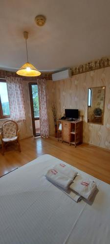 a bedroom with a bed with two towels on it at Family Hotel Emaly 1 in Bankya