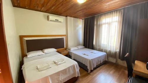 a small room with two beds and a window at Herton Boutique Hotel in Istanbul
