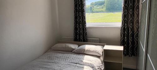 een kleine slaapkamer met een bed en een raam bij Modern two bedroom house near beach/ Durham City in Hawthorn