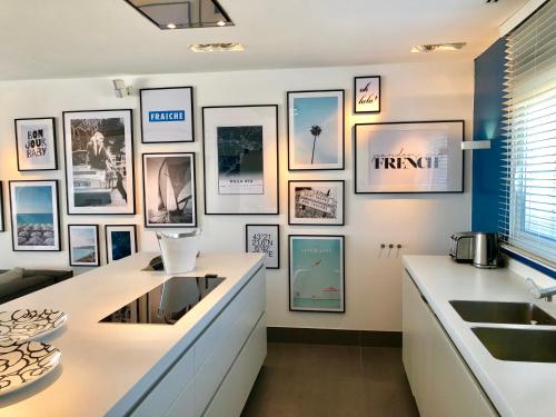 a kitchen with pictures on the wall at Vue panoramique sur la baie de St Tropez in Les Issambres