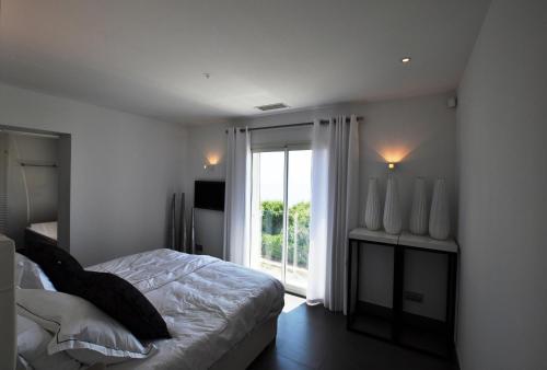 a bedroom with a bed and a large window at Vue panoramique sur la baie de St Tropez in Les Issambres