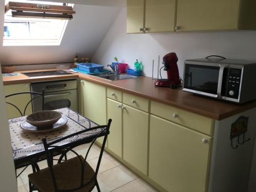 a small kitchen with a table and a microwave at Studio Cosy à Woluwé in Brussels