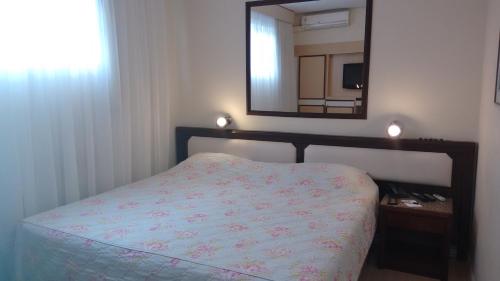 a bedroom with a bed with a mirror and a mirror at CHA Prime Curitiba in Curitiba