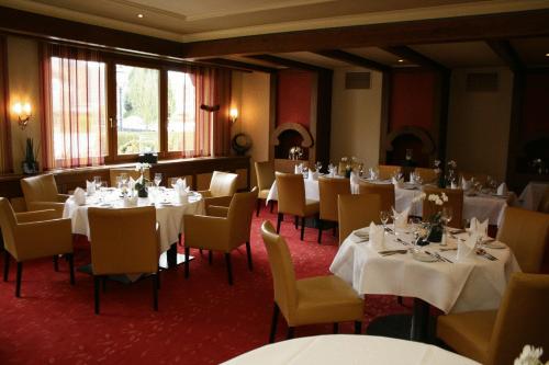 a dining room with white tables and chairs at Ringhotel Winzerhof in Rauenberg