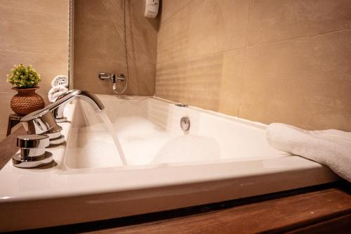 a white bath tub with a faucet in a bathroom at Hotel Mas de Xaxas in Camprodon
