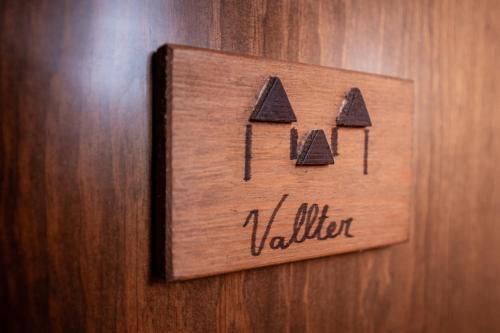 a wooden sign on a door with the word village at Hotel Mas de Xaxas in Camprodon