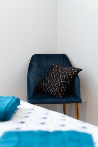 a blue chair with a pillow in a room at L'art déco, T3 Terrasse, classé meublé de tourisme in Rodez