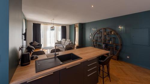 a kitchen with a counter and a living room at L'art déco, T3 Terrasse, classé meublé de tourisme in Rodez