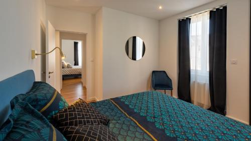1 dormitorio con 1 cama con edredón azul en L'art déco, T3 Terrasse, classé meublé de tourisme en Rodez
