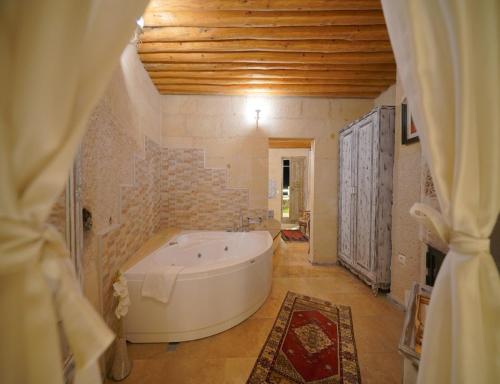 a large bathroom with a white tub in a room at Karlık Cave Suite Cappadocia in Uchisar
