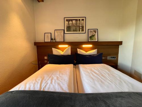 a bedroom with a bed with white sheets and blue pillows at Haus am Wald in Eltmann