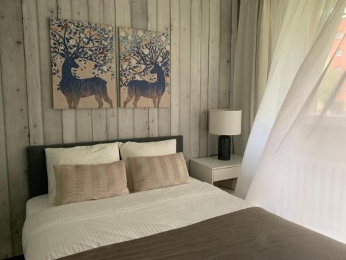 sypialnia z łóżkiem z dwoma obrazami jelenia na ścianie w obiekcie Mały Kwadrat Tychy w Tychach