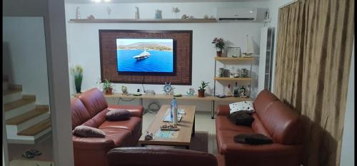 a living room with two leather couches and a tv at Casa Tim in Tulcea