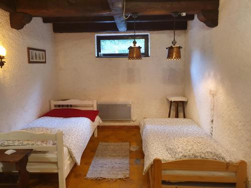 1 dormitorio con 2 camas y TV. en Orée du Bois en Abreschviller