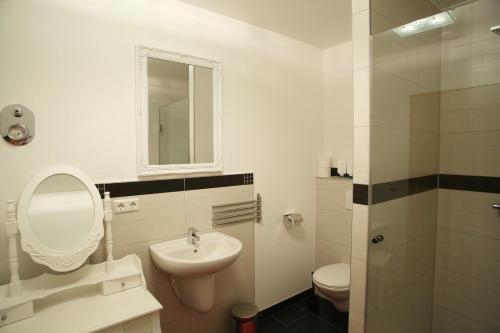 a bathroom with a sink and a toilet and a mirror at Apartment Paris in Mühlhausen