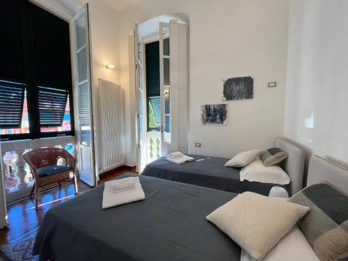 a room with three beds and a chair and a window at Cavour in Levanto