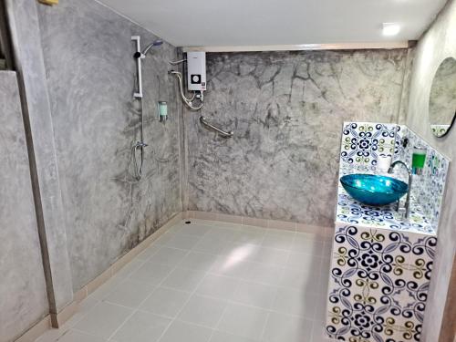 a bathroom with a shower and a blue sink at The Beach Boutique Resort in Ban Pak Nam Pran