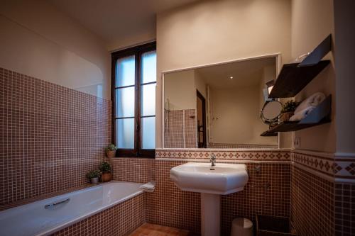 a bathroom with a sink and a tub and a mirror at Hotel Mas de Xaxas in Camprodon