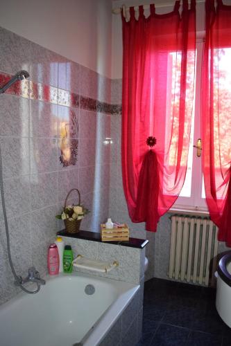 uma casa de banho com uma banheira e uma cortina de chuveiro vermelha. em La casa di ViSi em San Giacomo