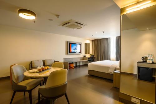 Habitación de hotel con cama, mesa y sillas en Amika Hotel,Madurai - Near Airport, en Madurai
