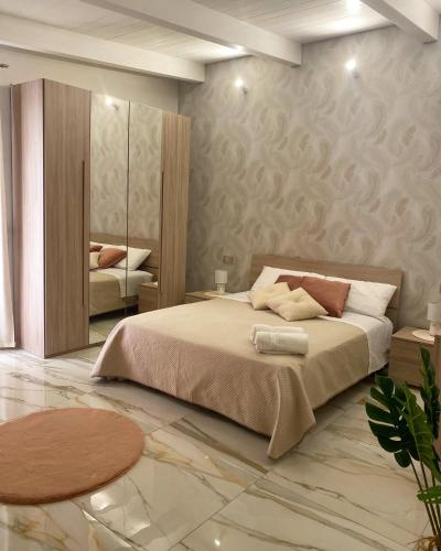 a bedroom with a large bed and a mirror at La Perla luxury rooms in Angri