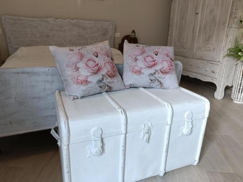 a white chair with two pillows and a bed at Locanda della Rocca di Camagna in Camagna Monferrato