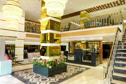 un vestíbulo de un centro comercial con escaleras y flores en UNITED HOTEL INTERNATIONAL en Yaundé