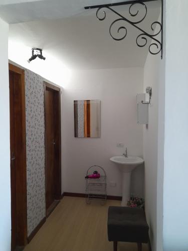 ein Badezimmer mit einem Waschbecken, einem Spiegel und einer Tür in der Unterkunft Espaço Jardim Curitiba in Curitiba
