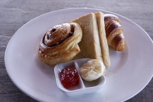 a plate of food with pastries and jam on it at Pemedal Beach Resort in Nusa Lembongan