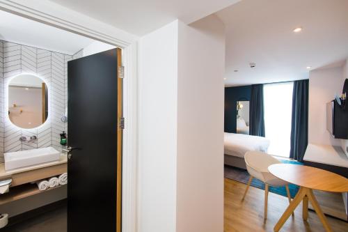 una habitación de hotel con una cama y una mesa y una habitación en Staybridge Suites - Cardiff, an IHG Hotel, en Cardiff