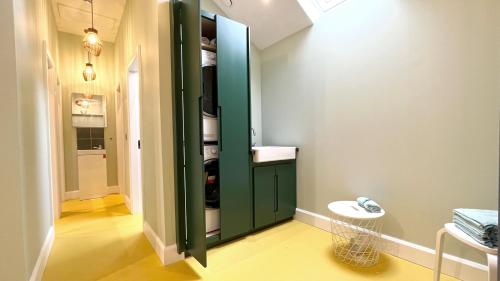 a bathroom with a green cabinet in a room at urchin Loft in Ardmore