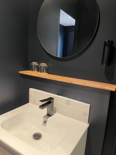 a bathroom with a sink and a mirror at HDLT le Suit’Appart face mer in Neufchâtel-Hardelot