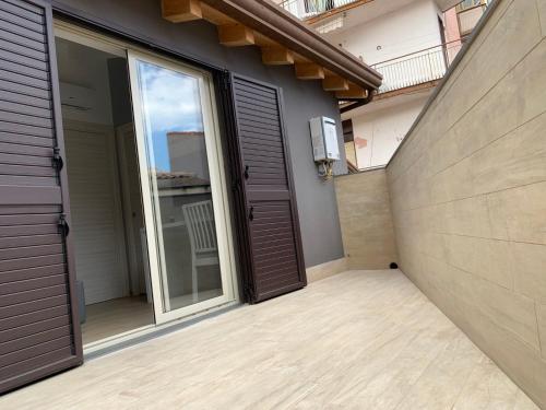 a patio with a door and a balcony at Casa vacanze Elegance in Catania