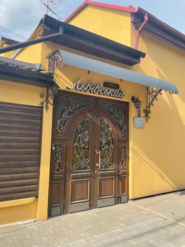 a yellow building with a large wooden door at Львівський in Lviv