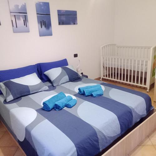 Una cama con dos almohadas azules encima. en Appartamento BLU - Colori del Lago D'Orta - NUOVA STRUTTURA A OMEGNA en Omegna