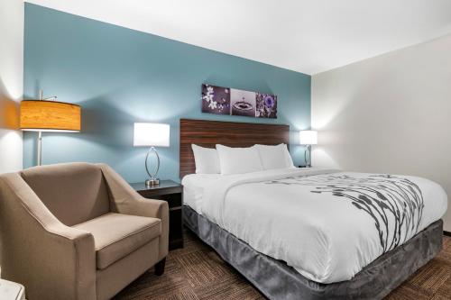 um quarto de hotel com uma cama e uma cadeira em Sleep Inn em Georgetown