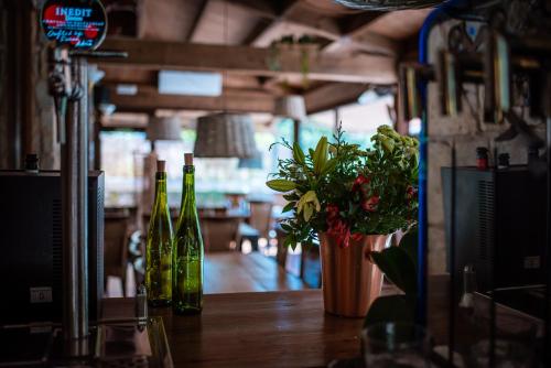 a table with bottles of wine and a vase of flowers at Hotel Mas de Xaxas in Camprodon