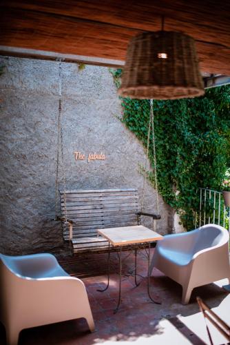 a patio with a table and chairs and a bench at Hotel Mas de Xaxas in Camprodon