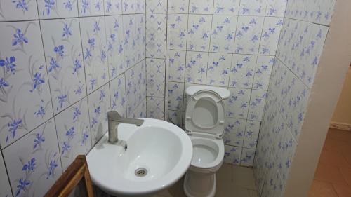 a bathroom with a toilet and a sink at La Case a Mamy in Nianing