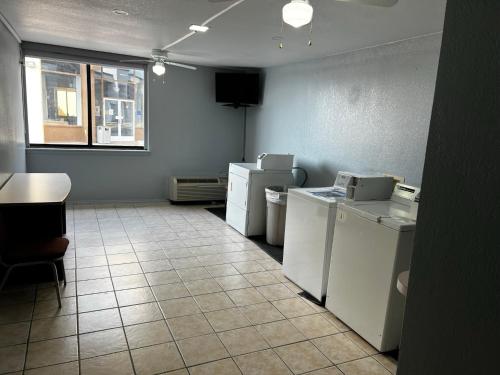 a laundry room with white appliances and a window at Super 8 by Wyndham Fort Worth Entertainment District in Fort Worth