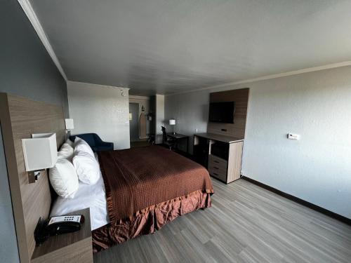 a hotel room with a bed and a desk at Super 8 by Wyndham Fort Worth Entertainment District in Fort Worth