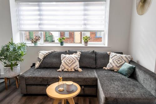 ein Wohnzimmer mit einem grauen Sofa und einem Tisch in der Unterkunft Cosy apartment in Newark upon Trent