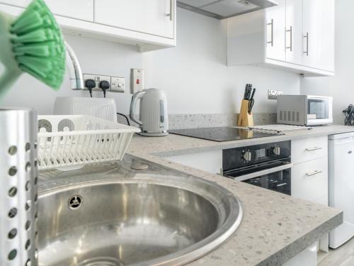 a kitchen with a stainless steel sink and appliances at Pass the Keys Pristine 1BR Apt Queens Uni Walk Everywhere in Belfast