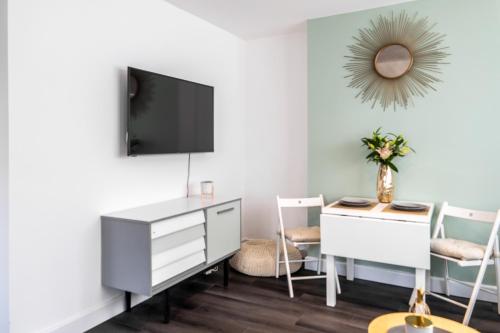 a living room with a desk and a tv on a wall at Cosy apartment in Newark-on-Trent