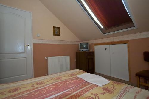 a bedroom with a bed and a skylight at Margaret Apartman in Egerszalók